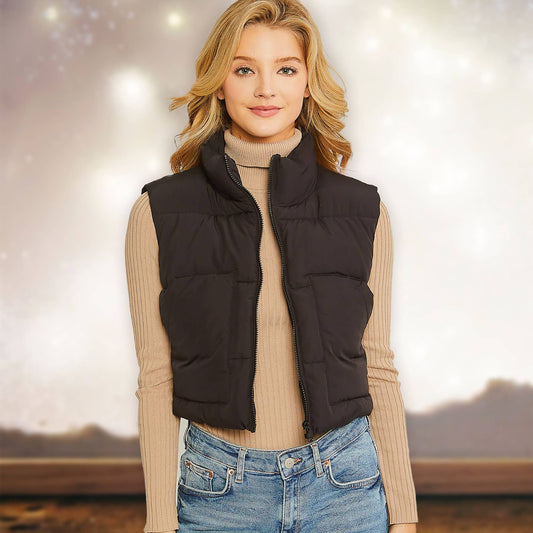 Woman wearing a black City Chill puffer vest over a beige sweater with a blurred background