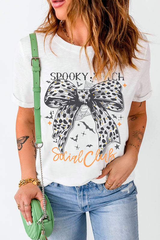 Halloween spooky witch social tee with witch graphic and leopard bow, styled with jeans for festive flair.
